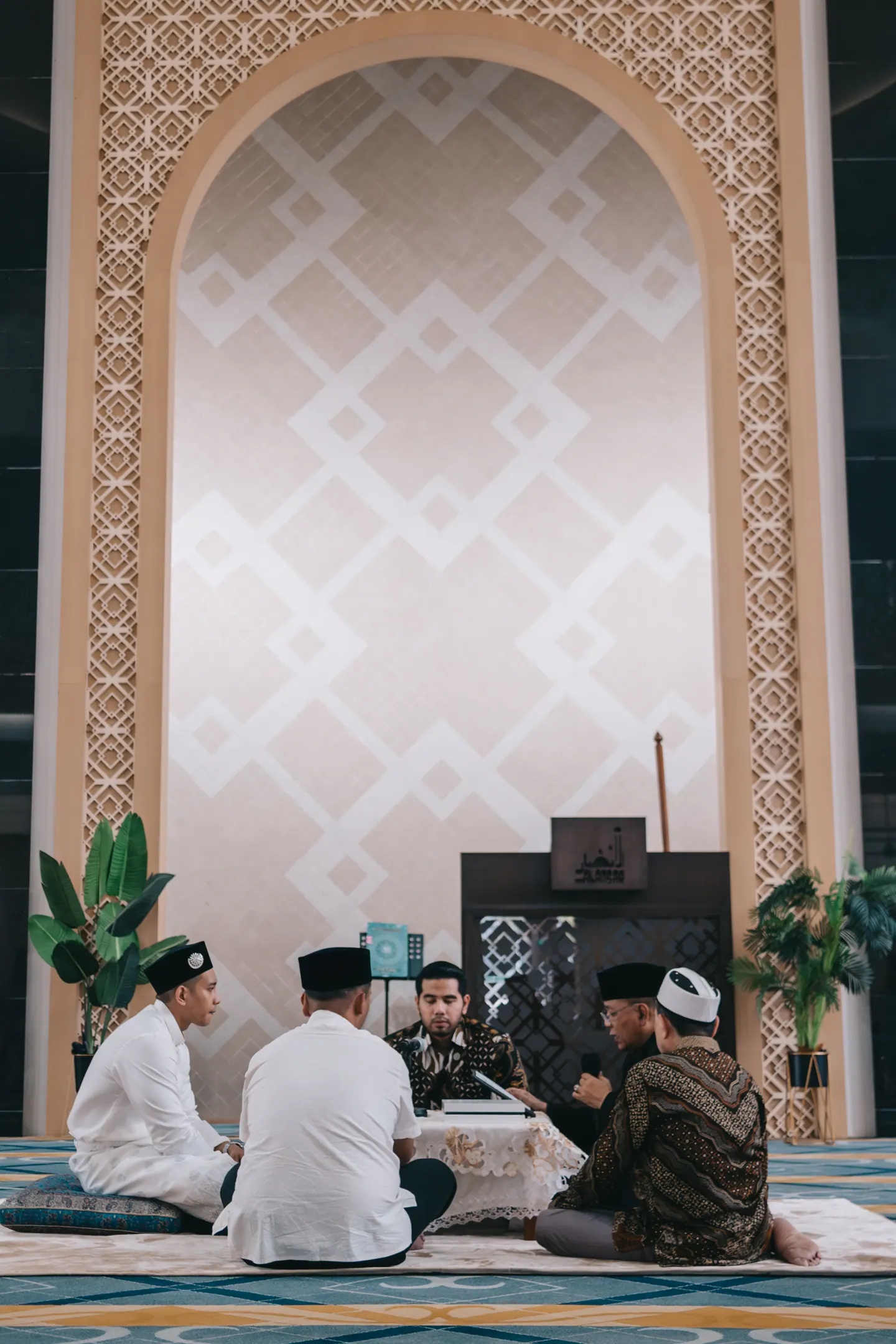 The solemnisation, small beneath a tall carved arch.
