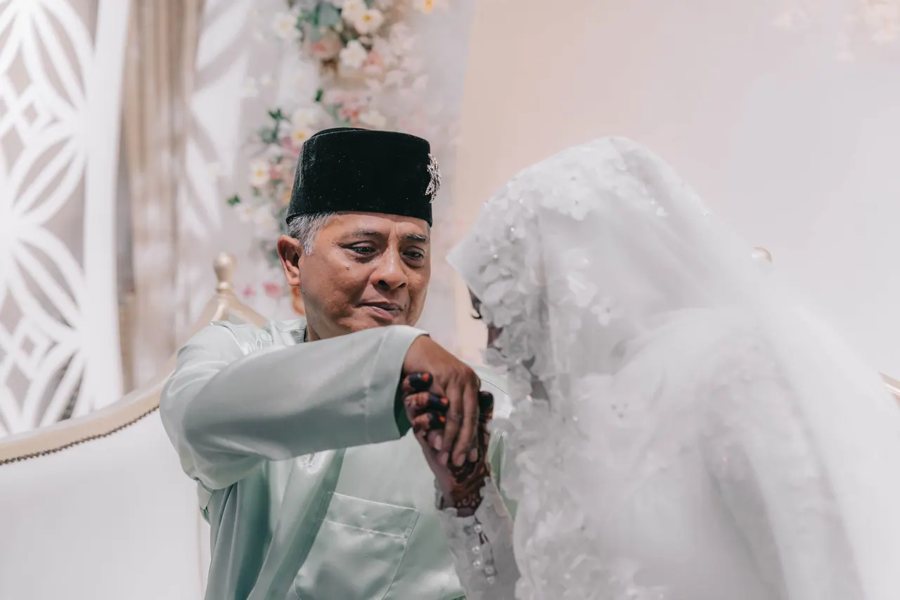 The bride bows to kiss the hand of an older man in mint green.