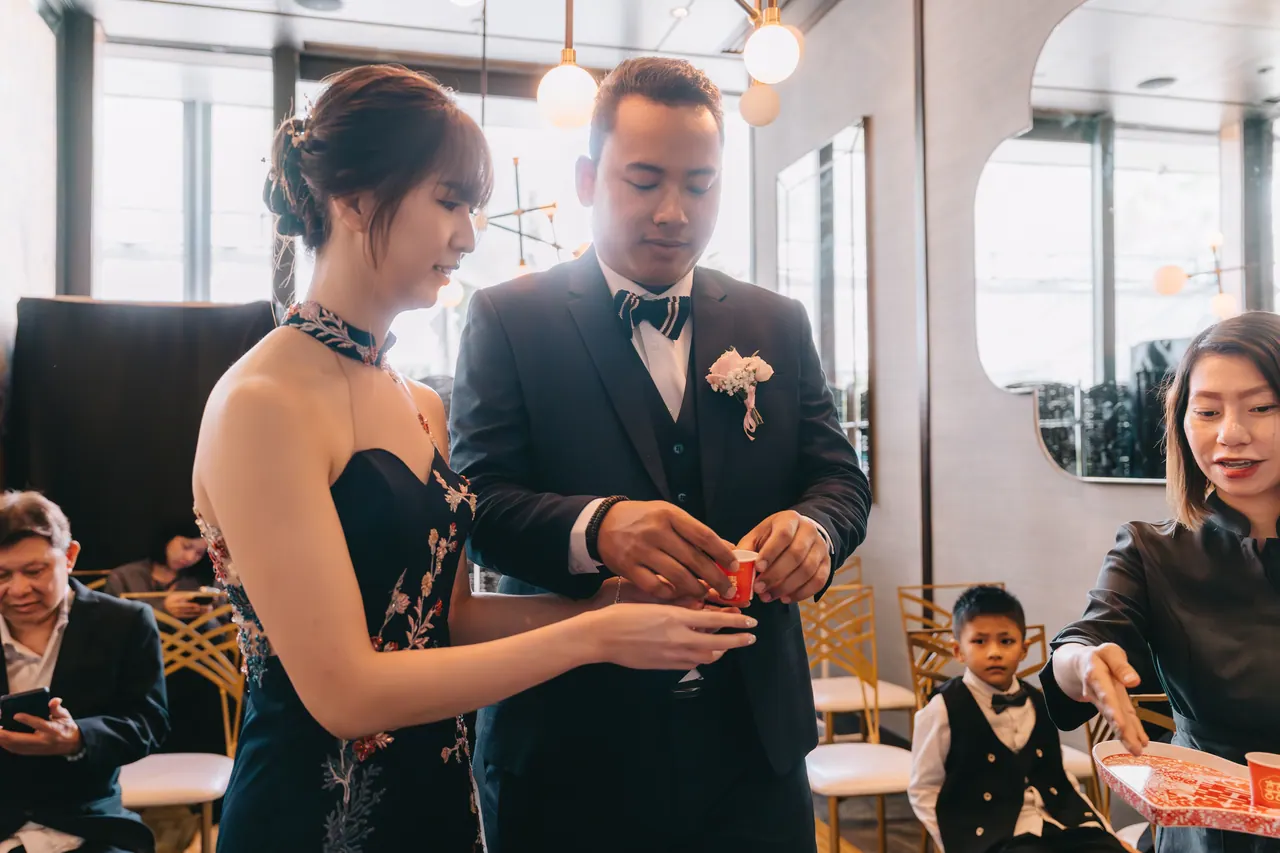Bride and groom during the tea ceremony, a page boy beside them.
