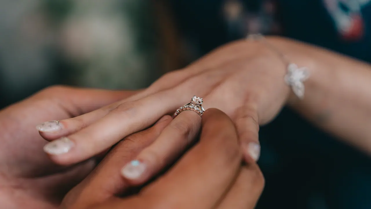 A ring slipped onto the bride’s finger, close up.