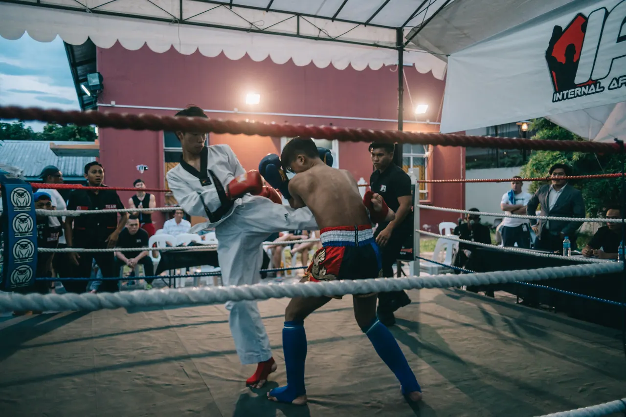 A fighter in a white gi faces his opponent.