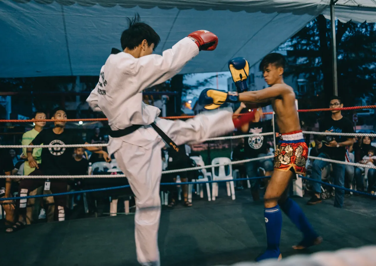 A high kick in the ring, the crowd watching.