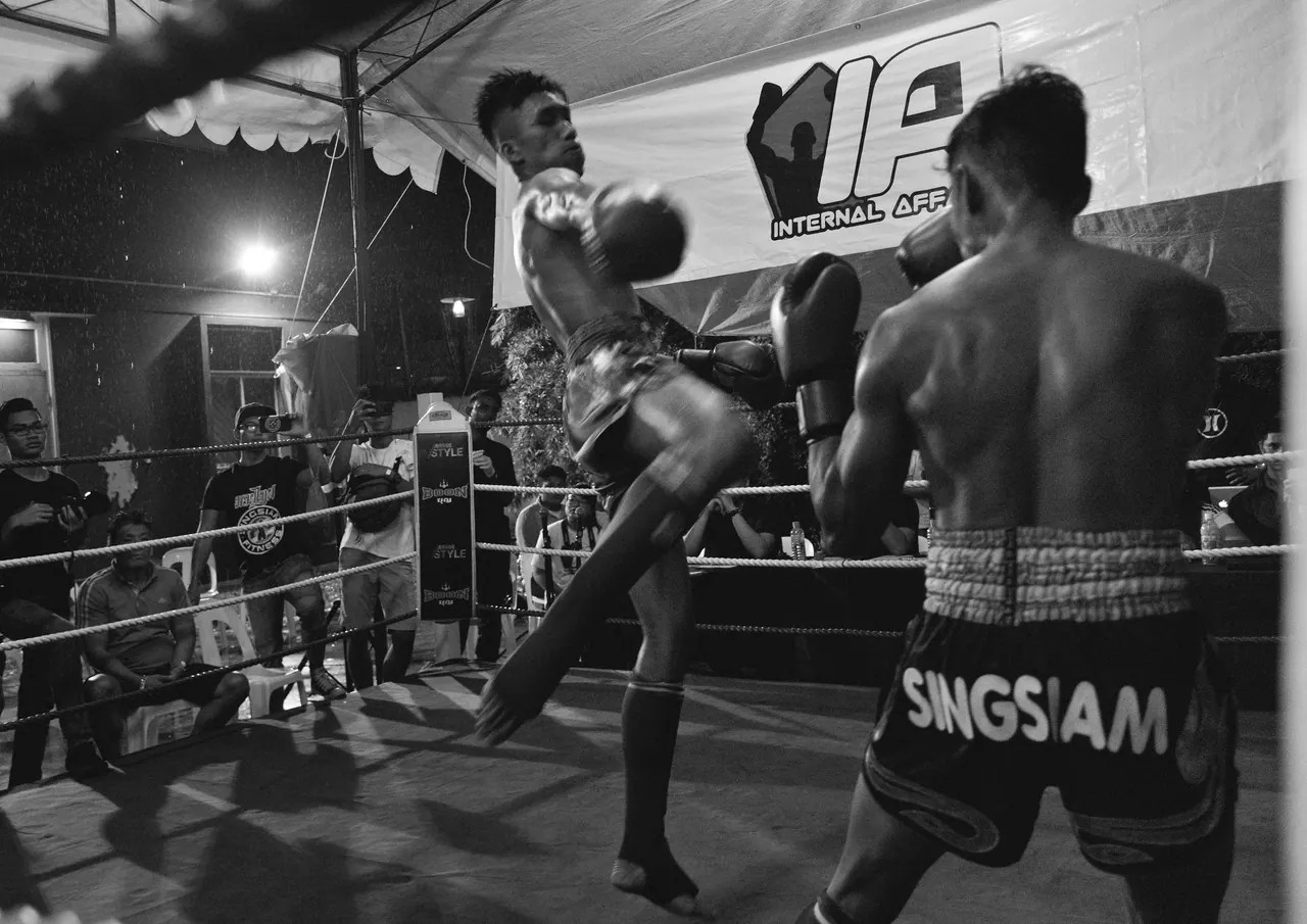 Black and white: a fighter lands a kick.