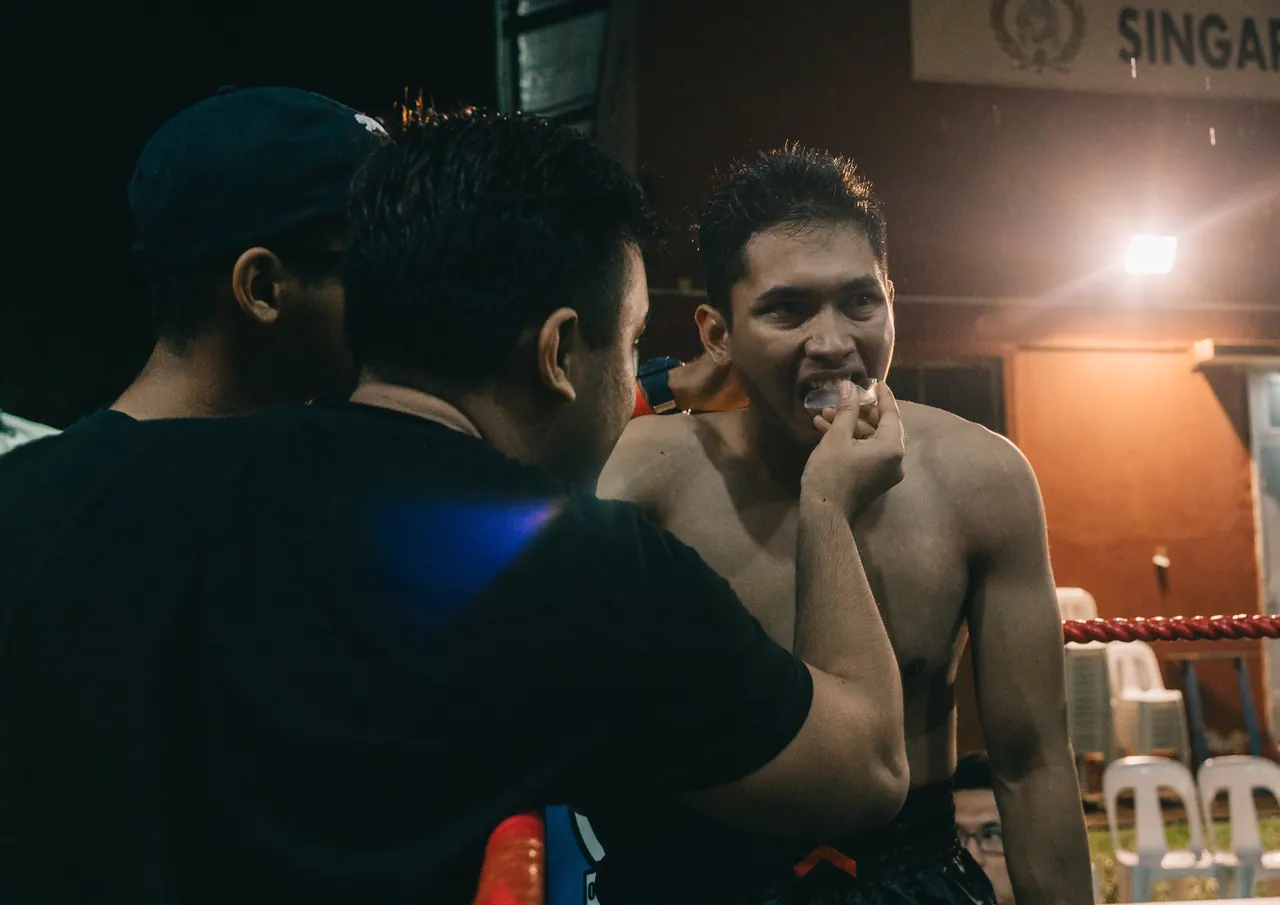 A coach talks to his fighter between rounds.