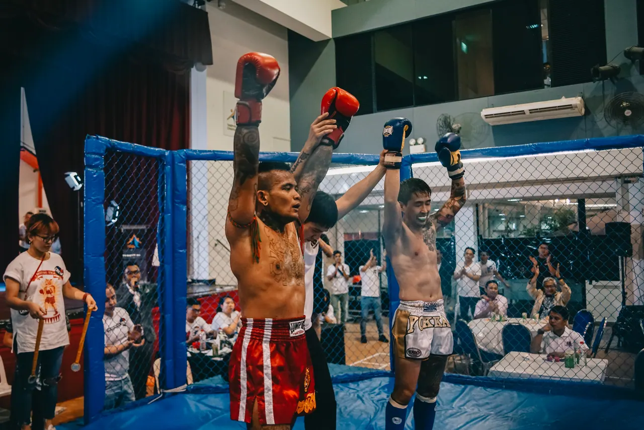 Two fighters raise their arms after the bout.