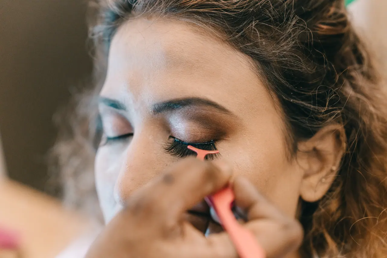 A make-up artist applies the bride’s eyeliner.
