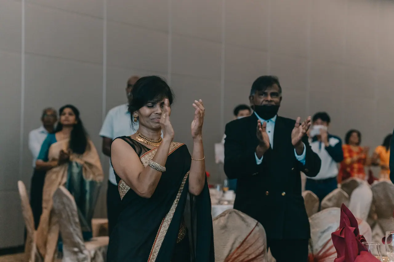 Guests clap and raise their hands.