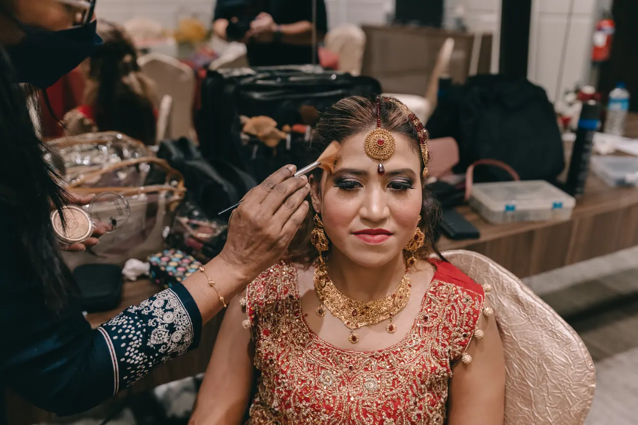 The bride in red and gold has her tikka set.