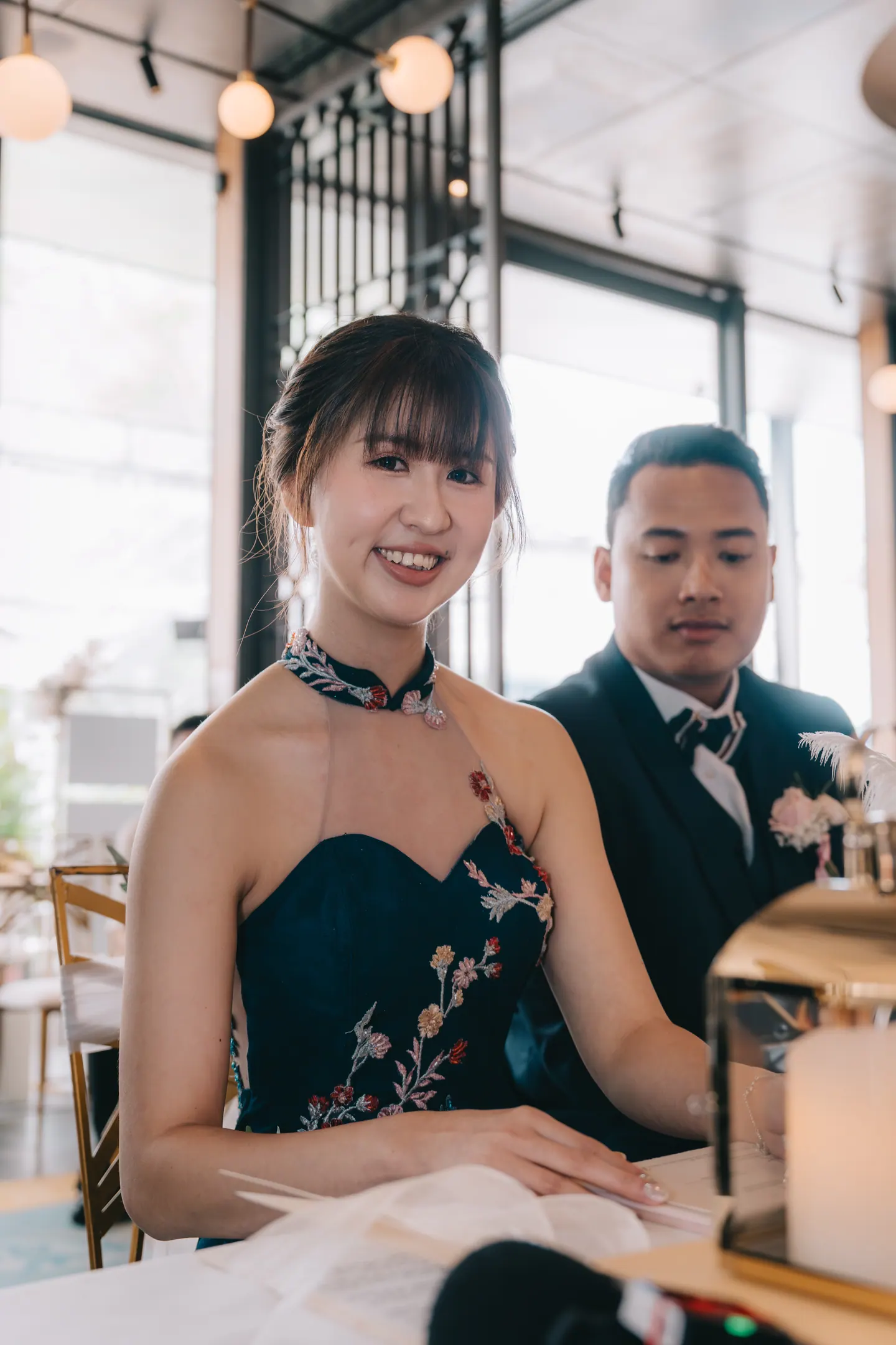 The bride signs, the groom beside her.