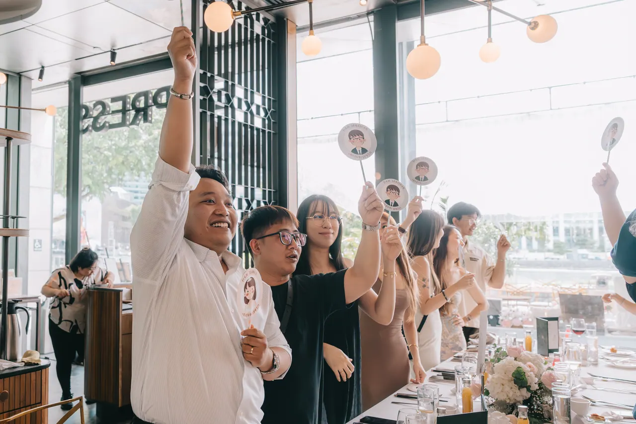 Guests raise cartoon faces of the couple during a game.