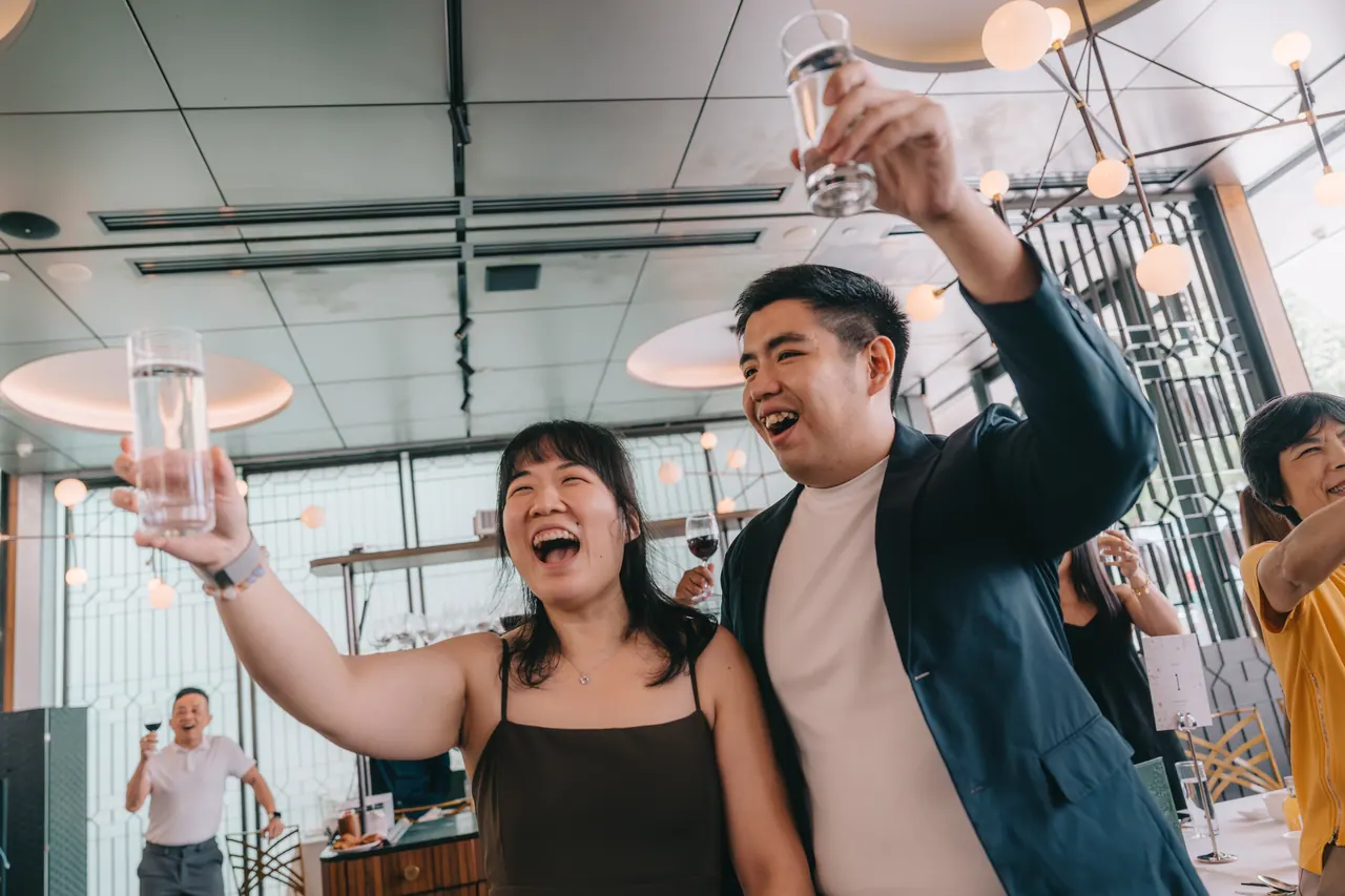 Guests raise their glasses and shout yam seng.