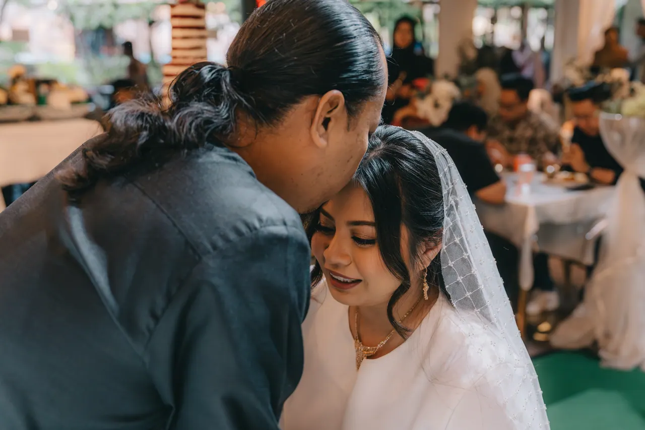 A guest presses his forehead to the bride’s.