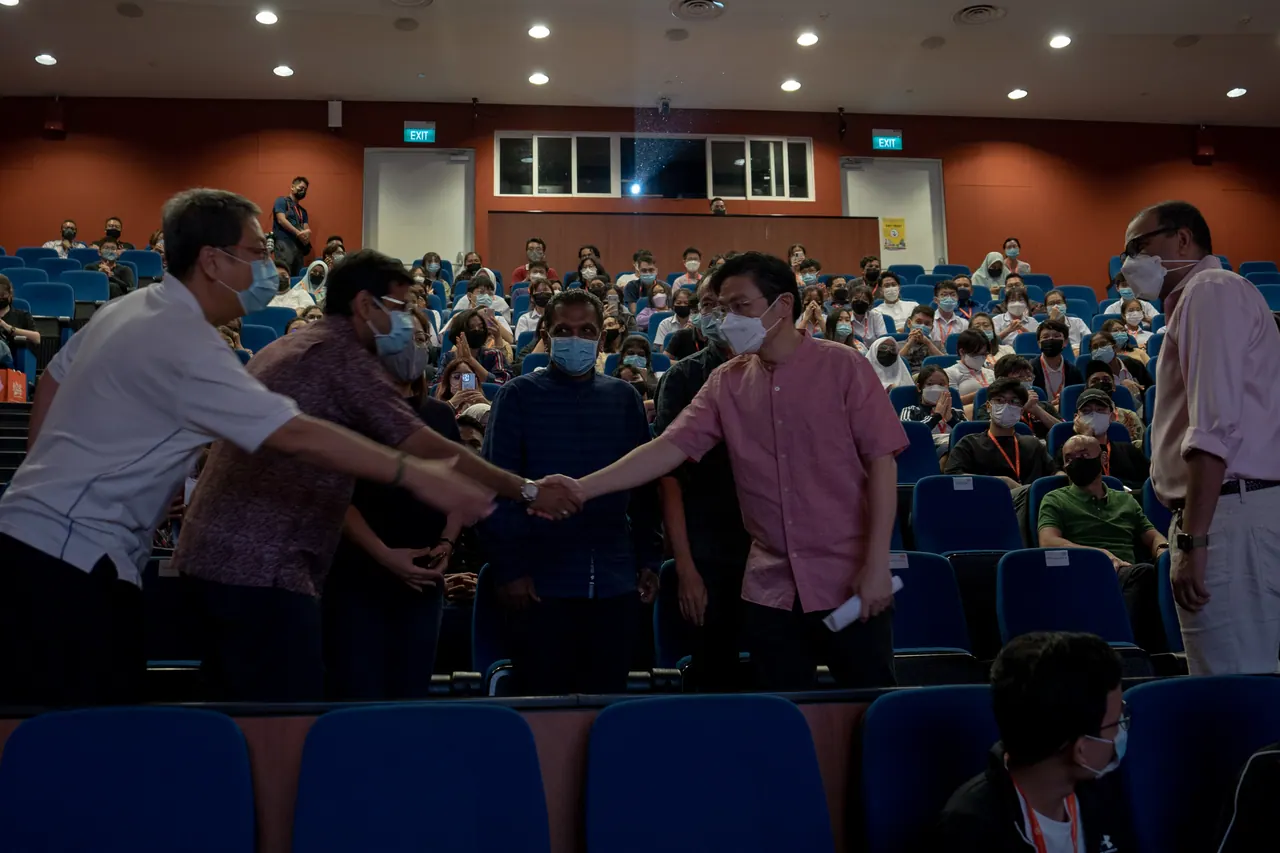 The guest of honour shakes hands with the audience.