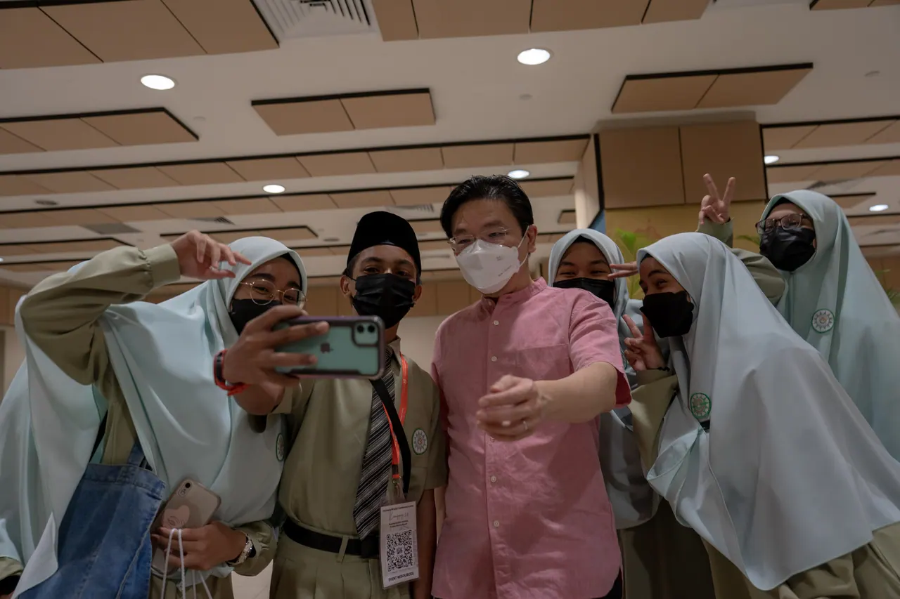 The guest of honour takes a selfie with students.