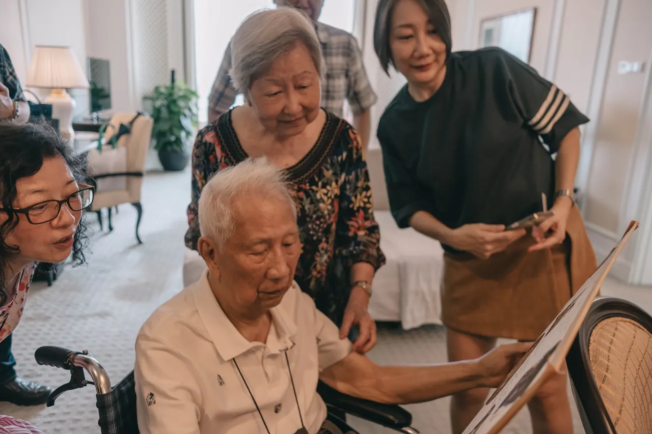 An older couple look through cards with family.
