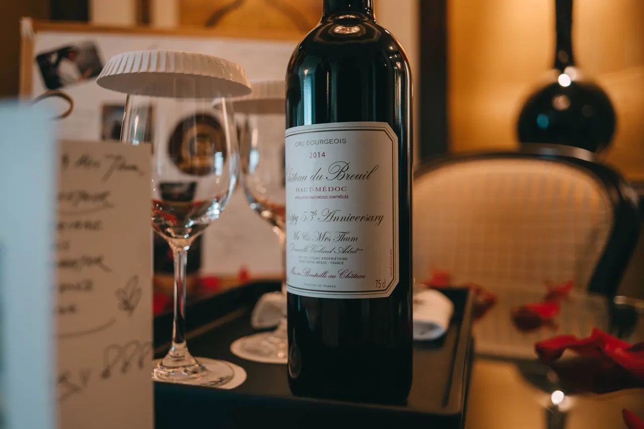 A bottle of wine and glasses on a table.