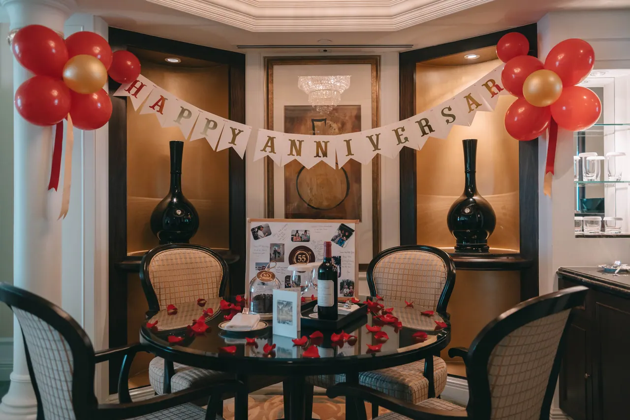 A dining table set beneath a happy anniversary banner.