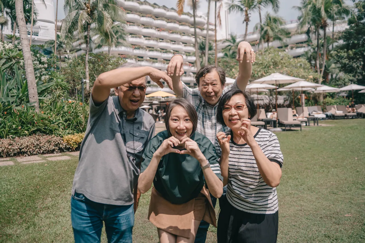 The family make heart shapes on the lawn.
