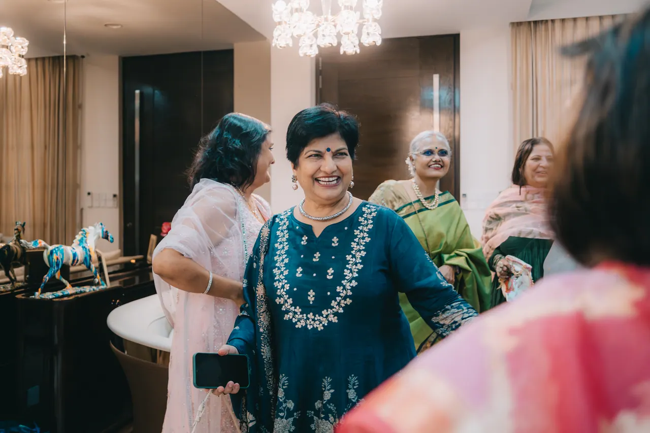 Guests greet each other in a bright living room.