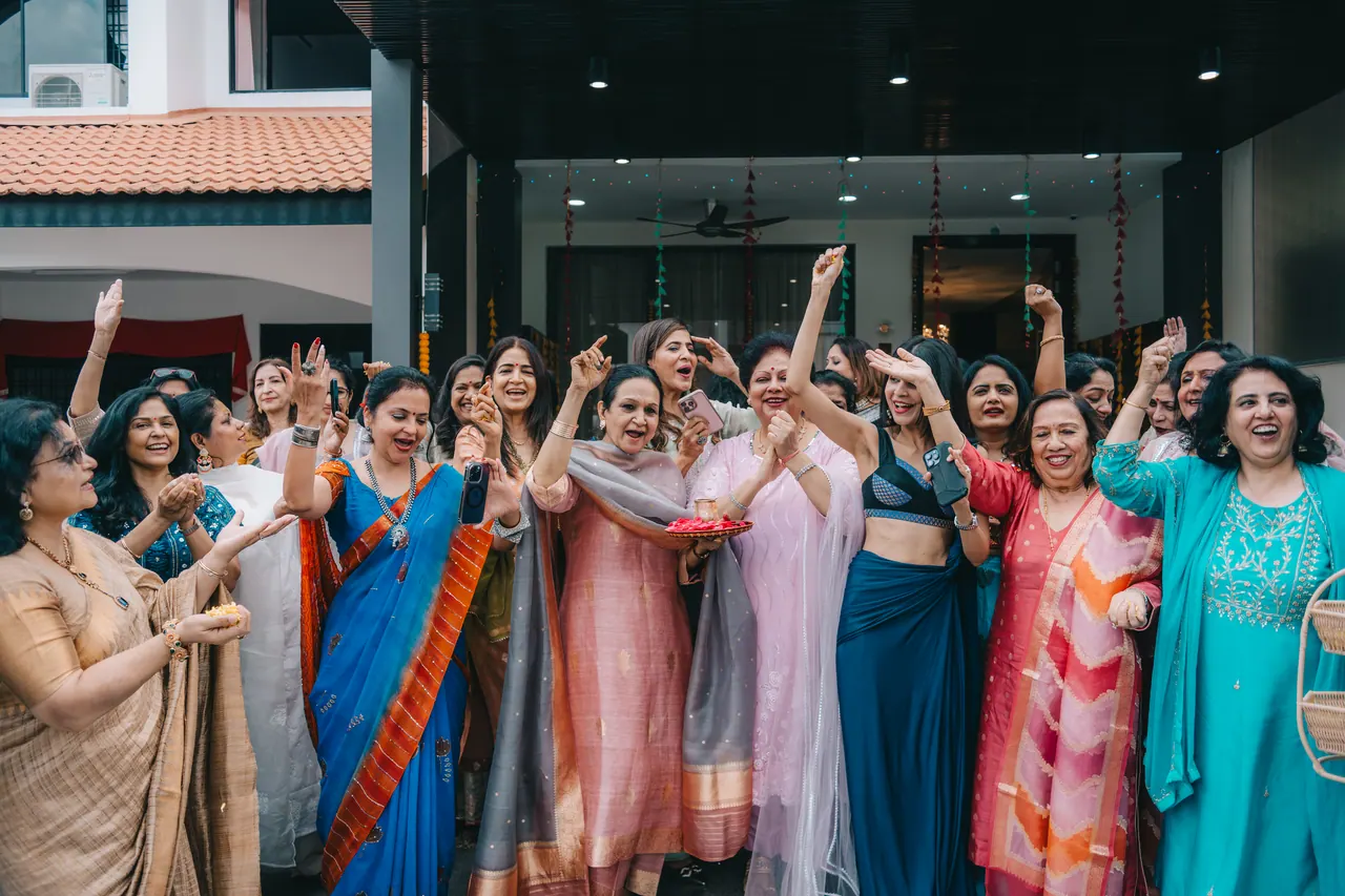 Guests in bright colours dance at the front door.