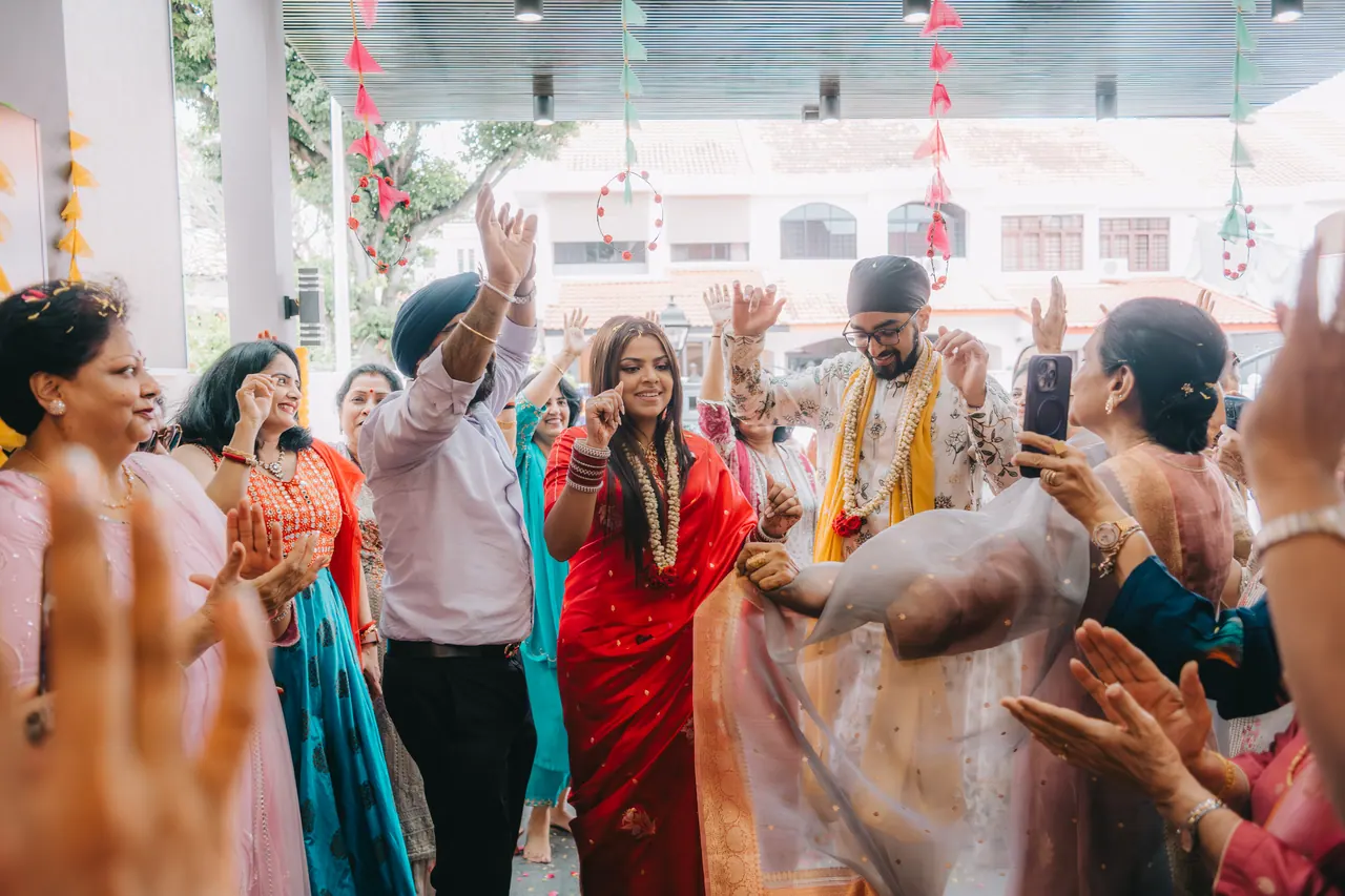 Guests dance around the couple on the driveway.