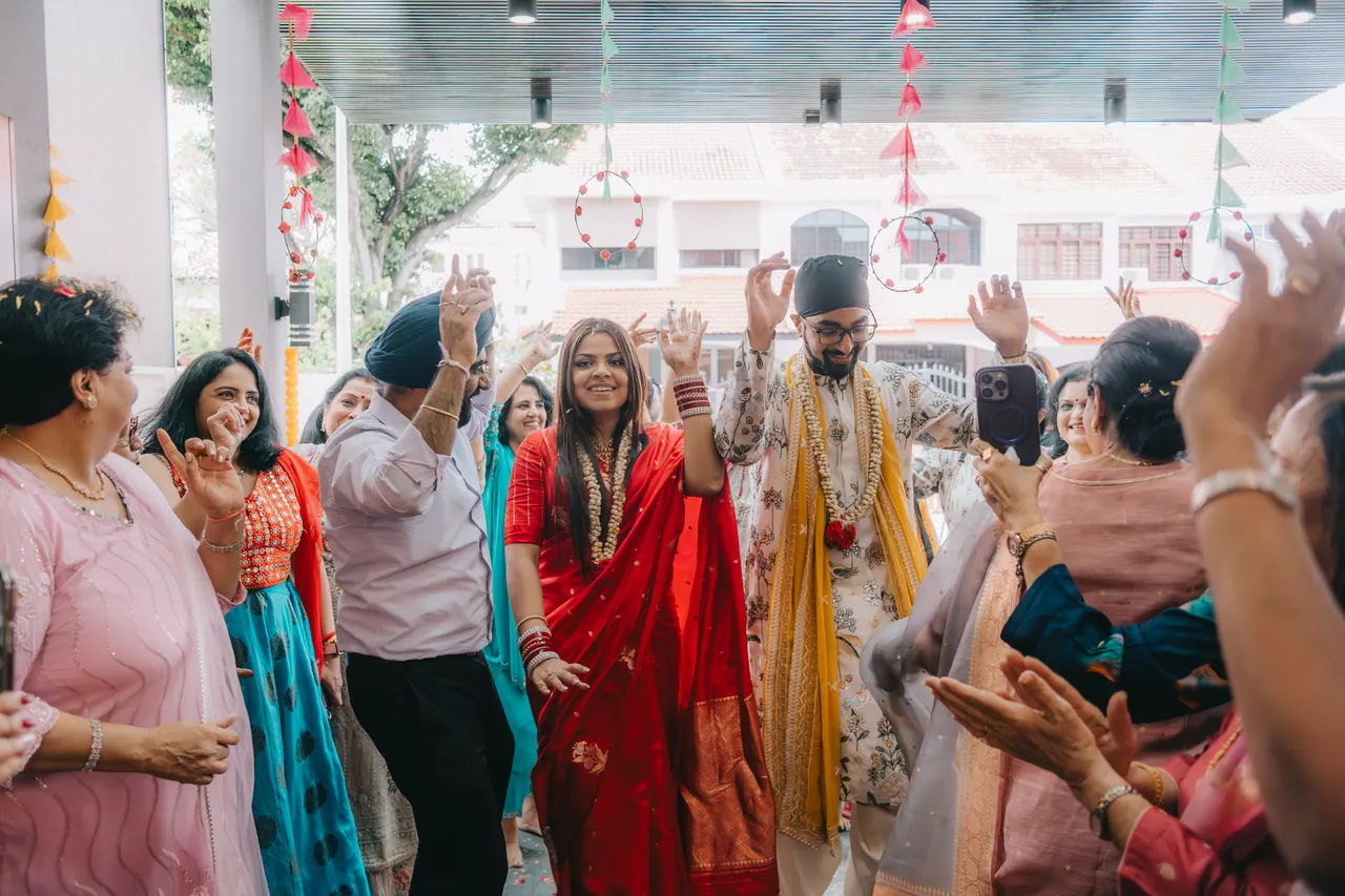 The couple dance in, surrounded by guests.