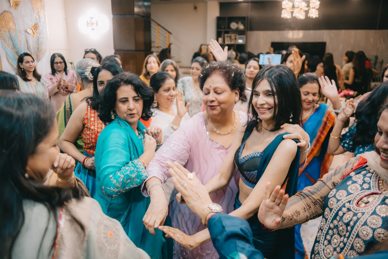 Women dance in a circle, clapping.