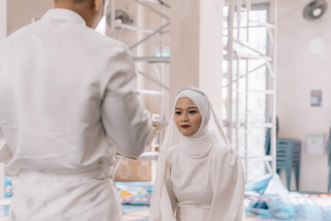 The groom faces the bride; she looks up at him.