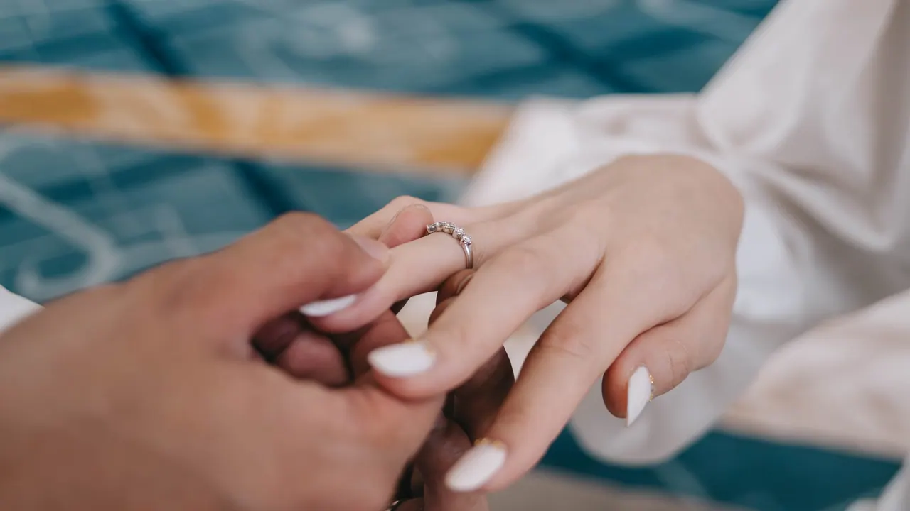 A ring slipped onto the bride’s finger, close up.