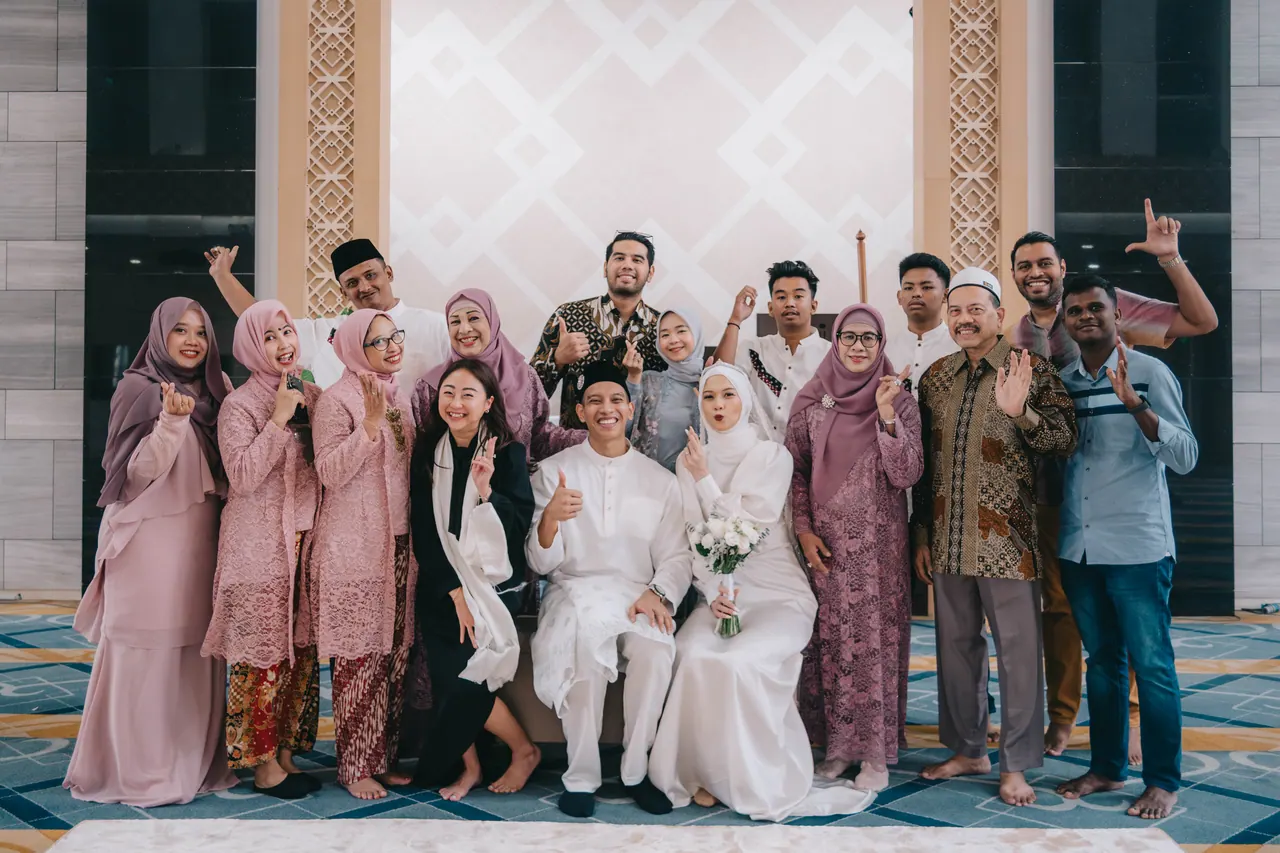 A large family group cheers around the couple.