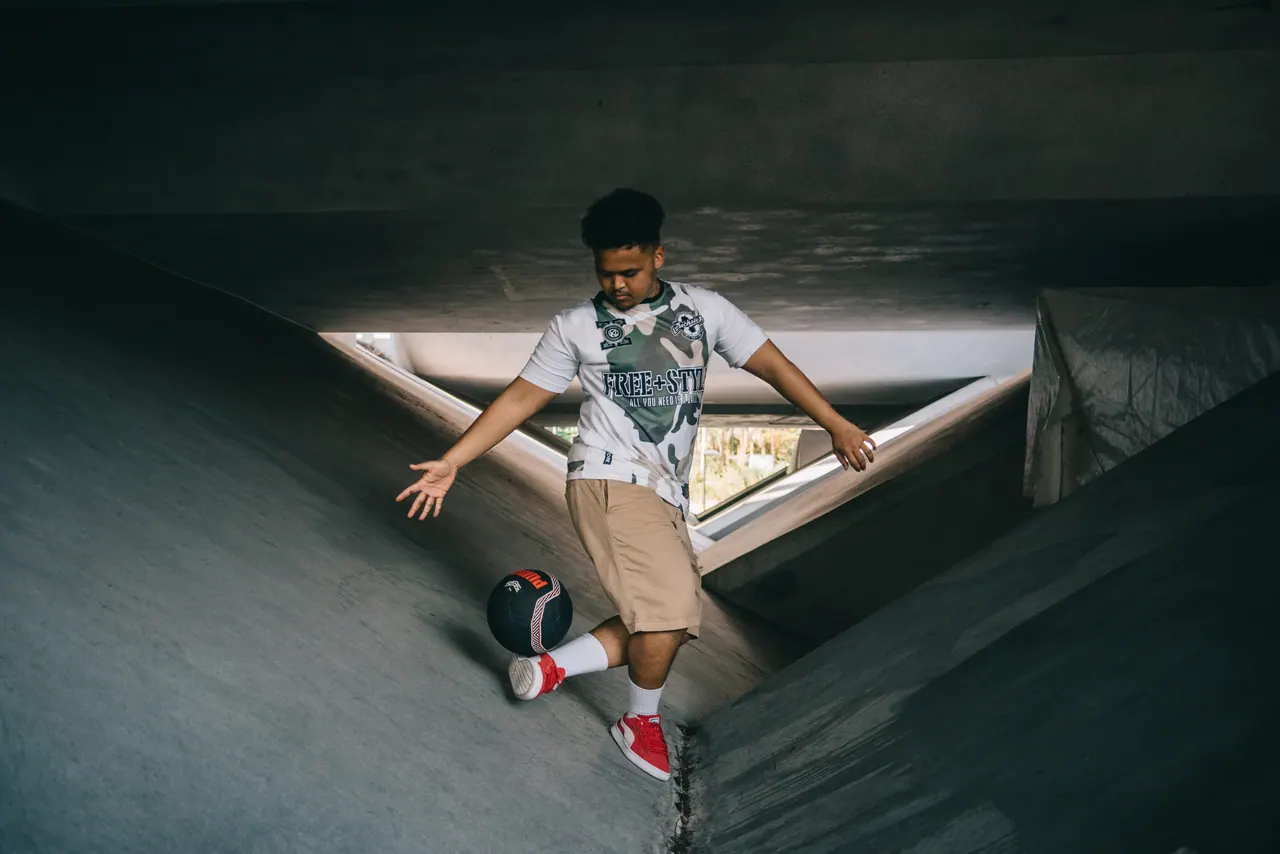 A freestyler mid-trick in a concrete stairwell.