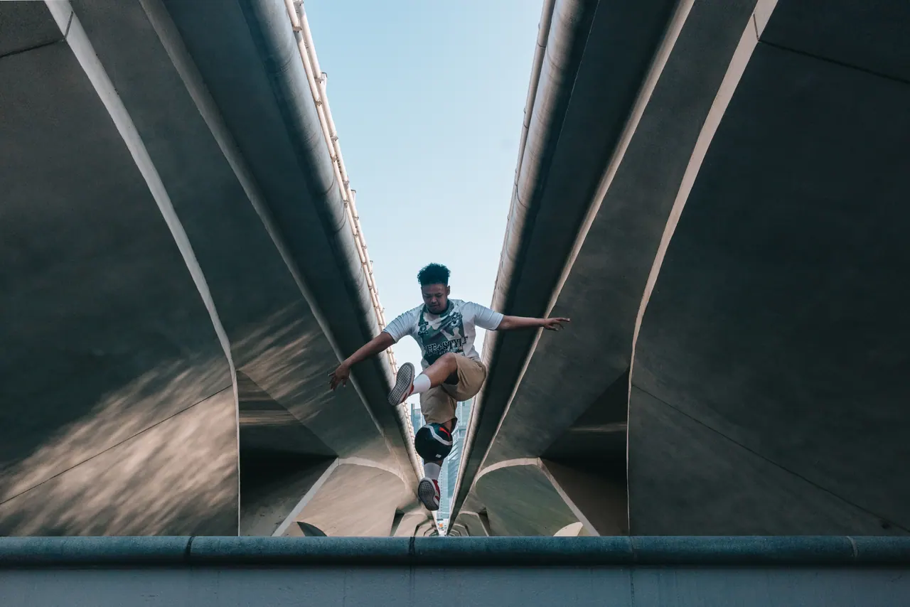 A freestyler jumps between the curves of a bridge.